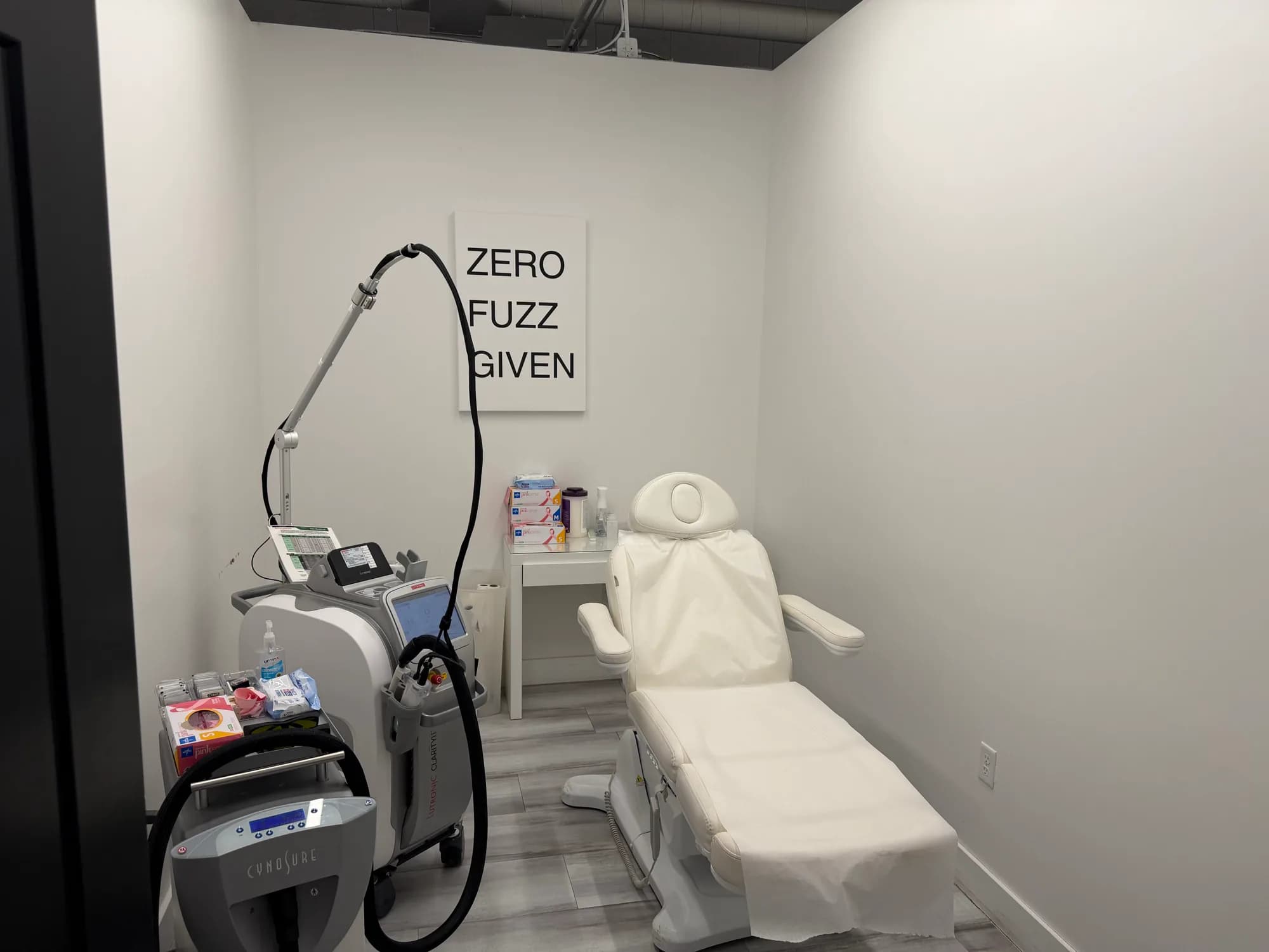 Laser treatment room with a treatment chair and laser equipment at Beauty Lab + Laser in Murray, Utah.