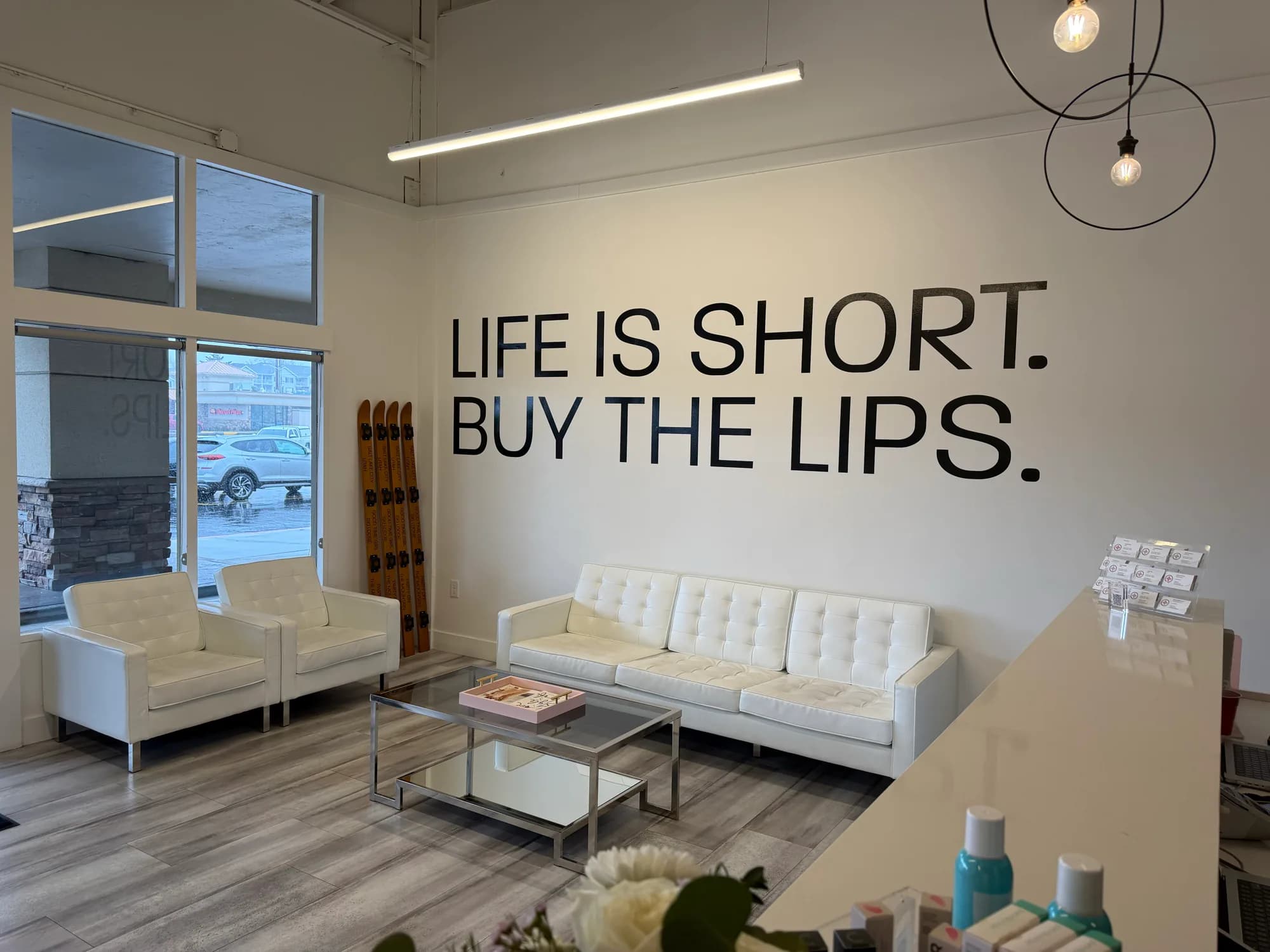 Waiting room with white seating at Beauty Lab + Laser in Murray, Utah.