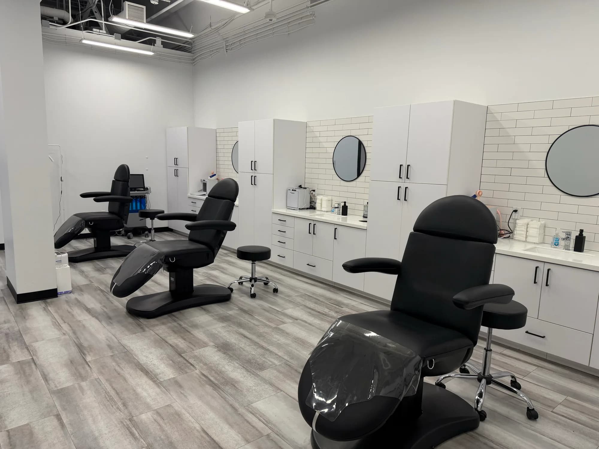 Injectable treatment room with black treatment chairs at Beauty Lab + Laser in Riverton, Utah.