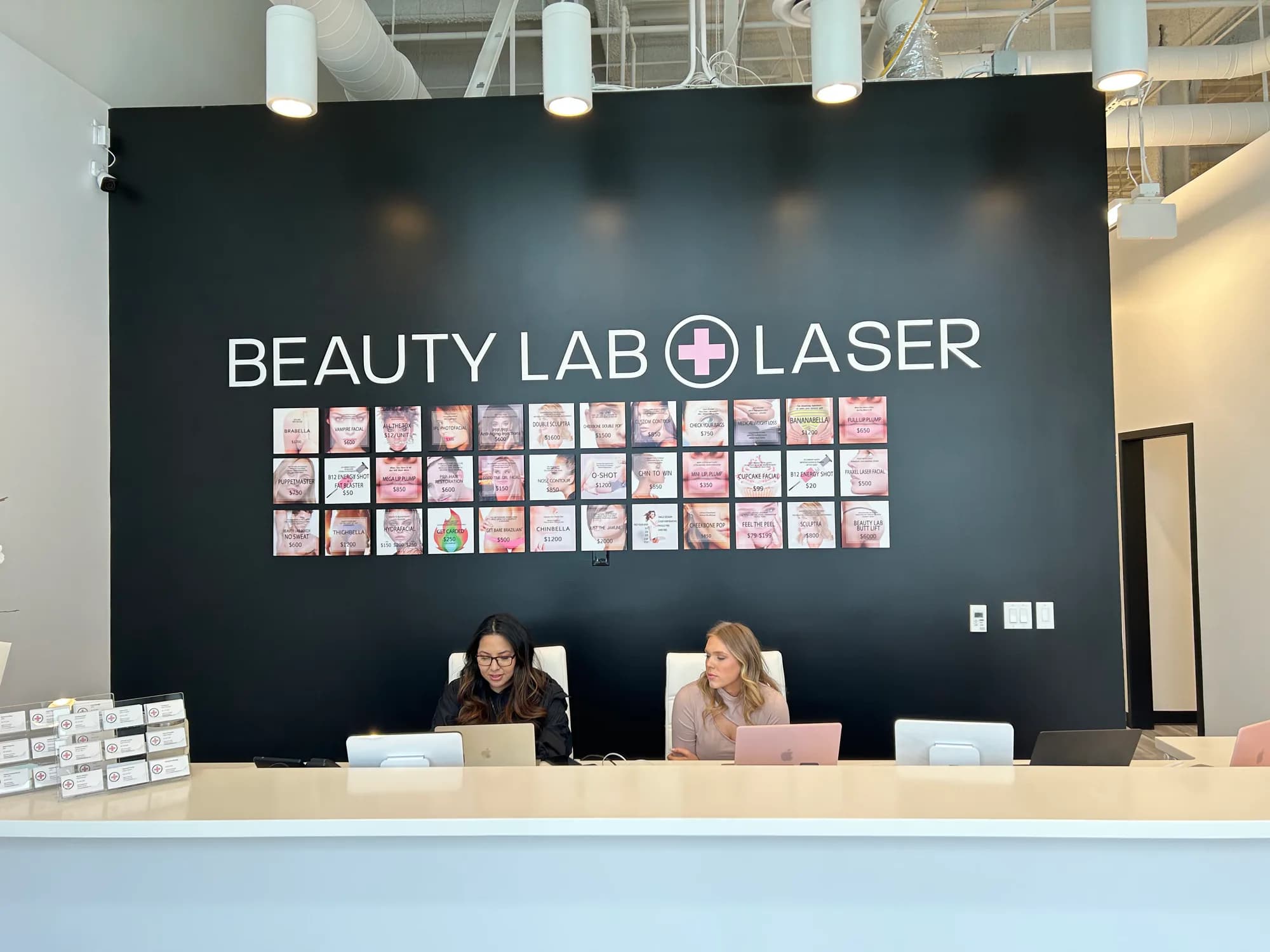Two team members at the reception desk inside Beauty Lab + Laser in Riverton, Utah.
