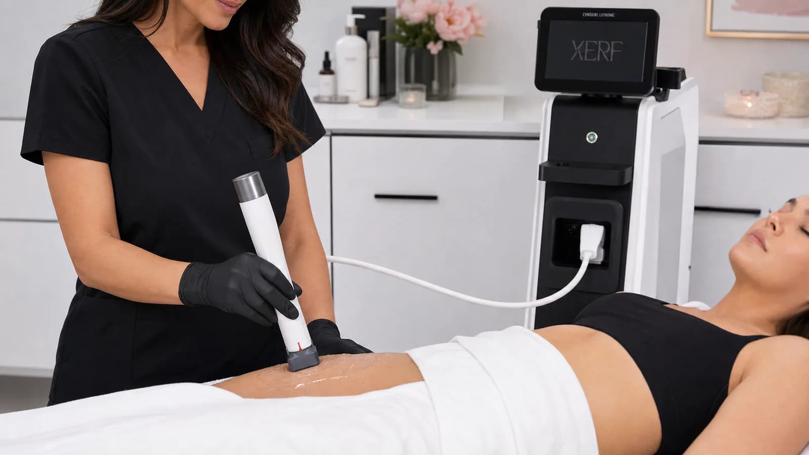 Provider performing XERF treatment across an adult client's abdomen.
