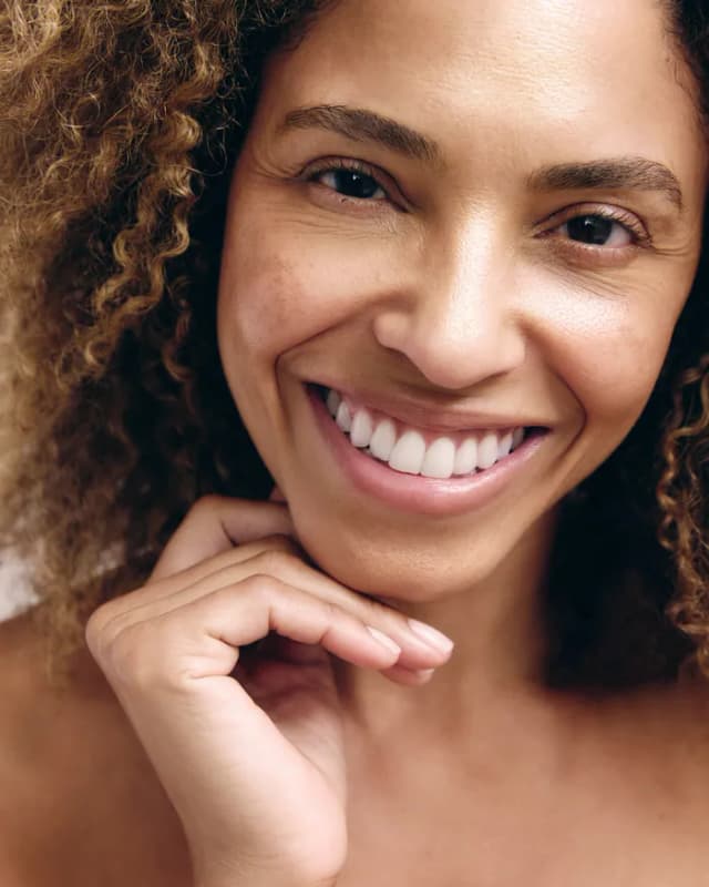 Woman smiling with hydrated, glowing skin.